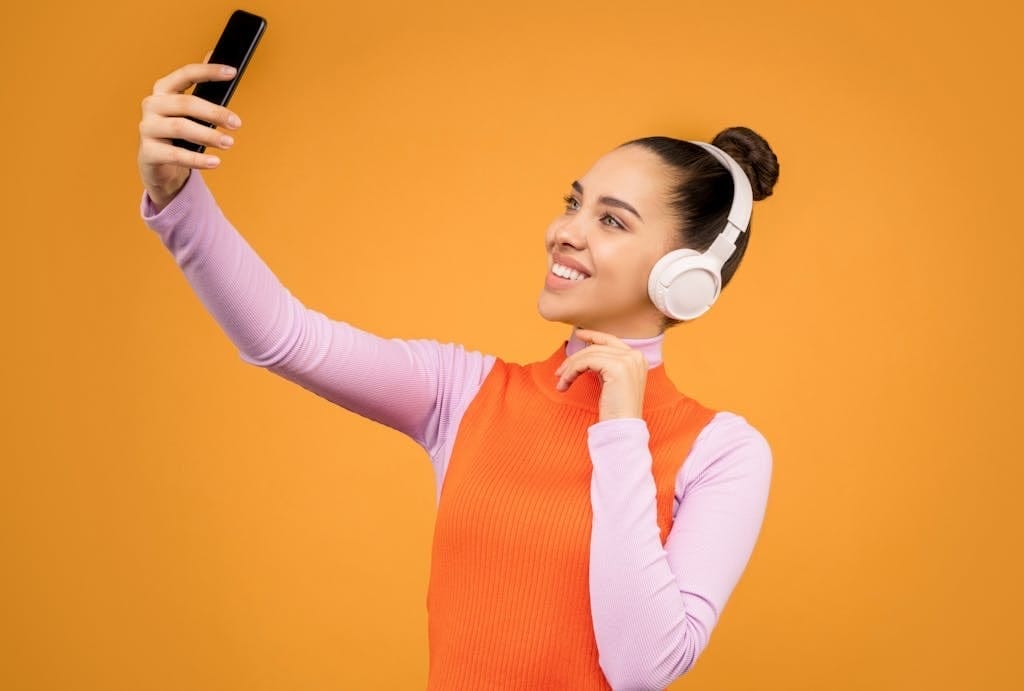 Woman in Knitted Long Sleeve Shirt Holding Black Mobile Phone